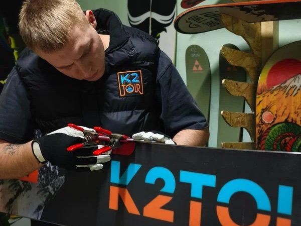 Мастер K2TOUR готовит сноуборд к выдаче в Шерегеше